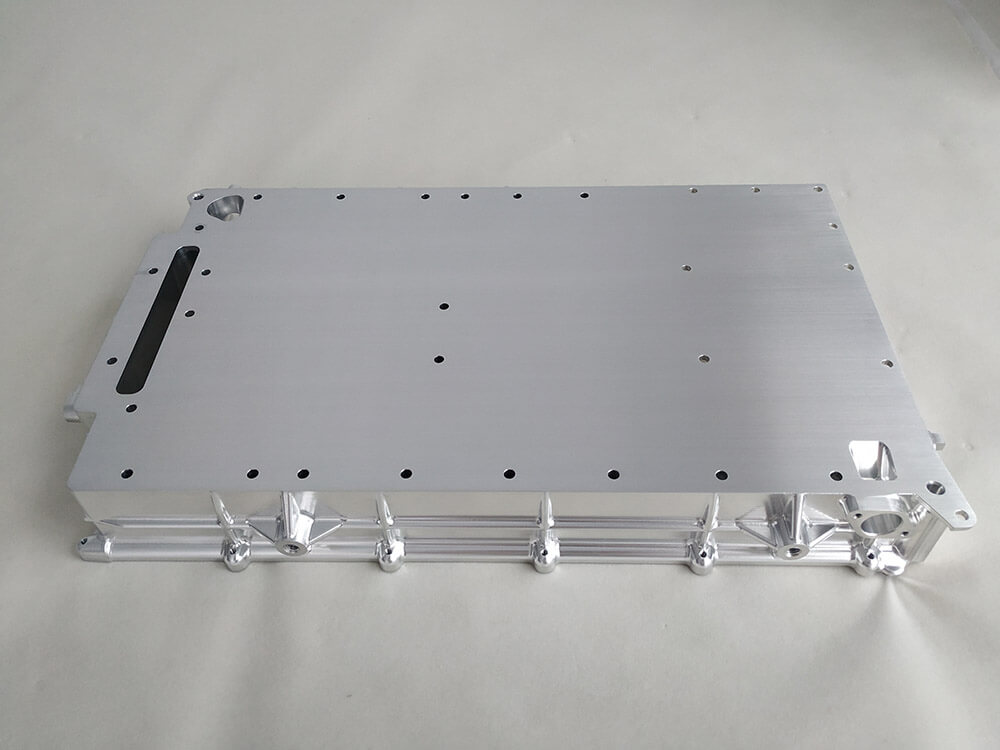 A machined aluminum structural plate with a drilled hole pattern, a slot, and a tubular support frame